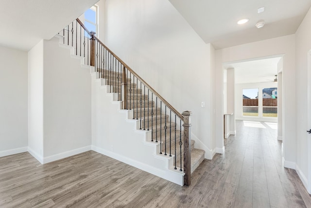 stairs with ceiling fan and wood-type flooring