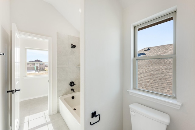 bathroom featuring tile patterned floors, tiled shower / bath, lofted ceiling, and toilet