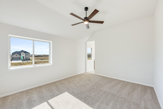 carpeted empty room with ceiling fan and vaulted ceiling