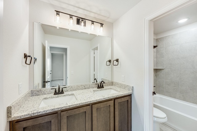 full bathroom with vanity, tiled shower / bath combo, and toilet