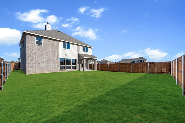 rear view of property featuring a yard