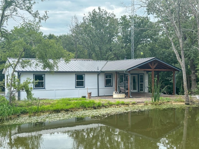 rear view of house featuring a water view