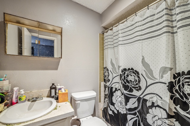 bathroom featuring vanity, toilet, and a textured ceiling