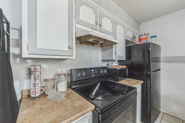 kitchen with white cabinetry, black appliances, light tile patterned floors, and a textured ceiling