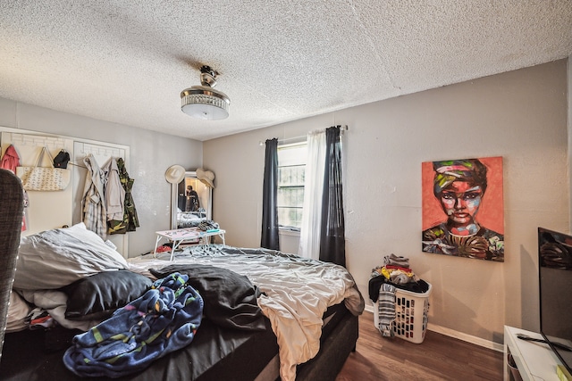 bedroom featuring wood-type flooring and a textured ceiling