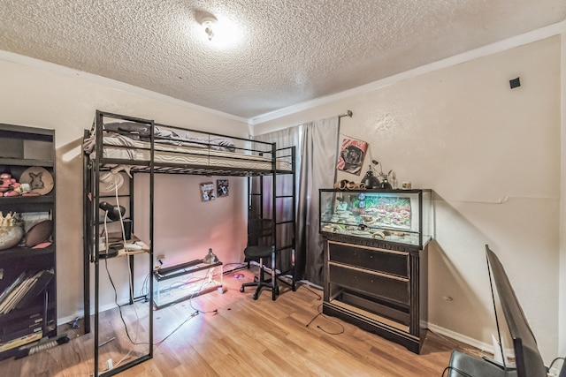 bedroom with wood-type flooring and a textured ceiling