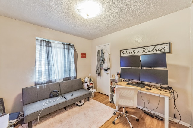 office with light hardwood / wood-style floors and a textured ceiling