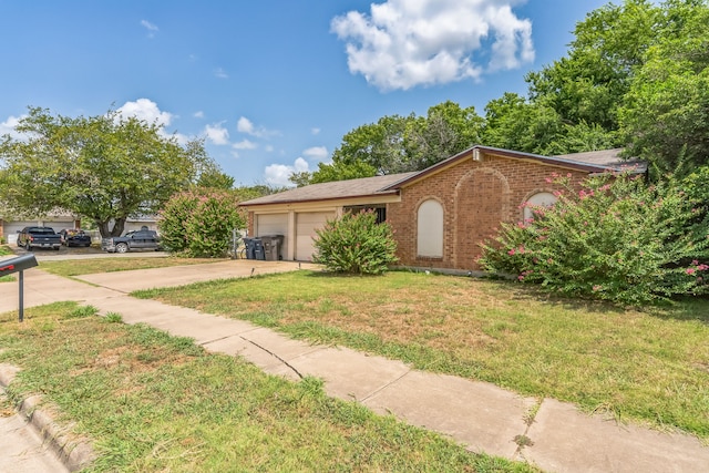 ranch-style home featuring a garage and a front lawn