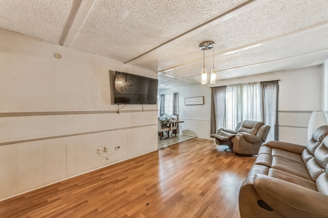 living room featuring a textured ceiling and light wood-type flooring