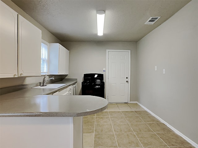 kitchen with white cabinets, light tile patterned flooring, sink, and kitchen peninsula