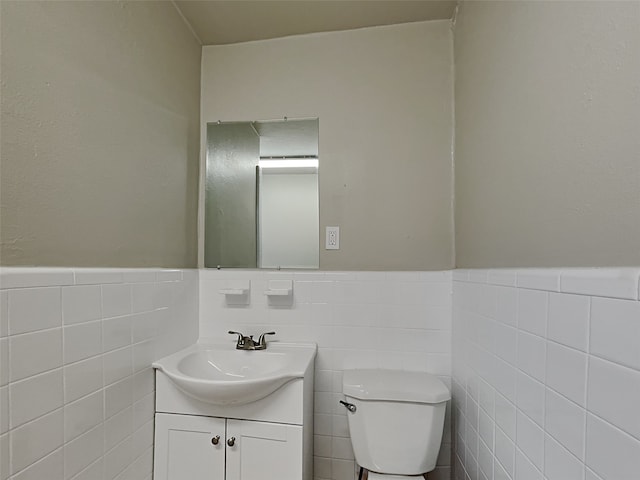 bathroom with tile walls, backsplash, toilet, and vanity