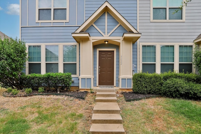 view of exterior entry featuring a yard