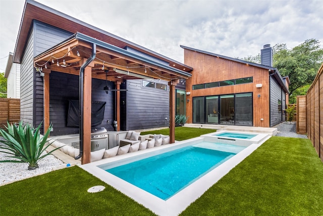 rear view of house featuring a pool with hot tub and a yard