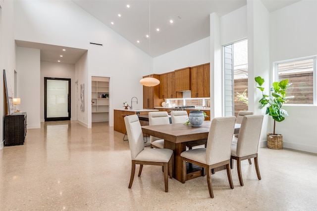 dining space featuring sink and high vaulted ceiling