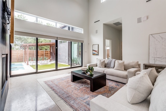 living room featuring concrete flooring and a high ceiling