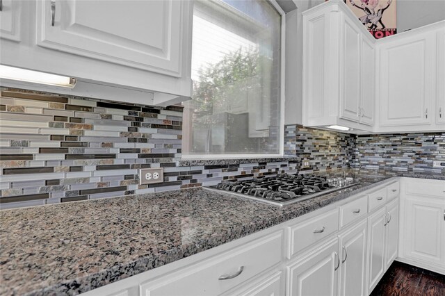 kitchen featuring white cabinets, backsplash, and stone counters