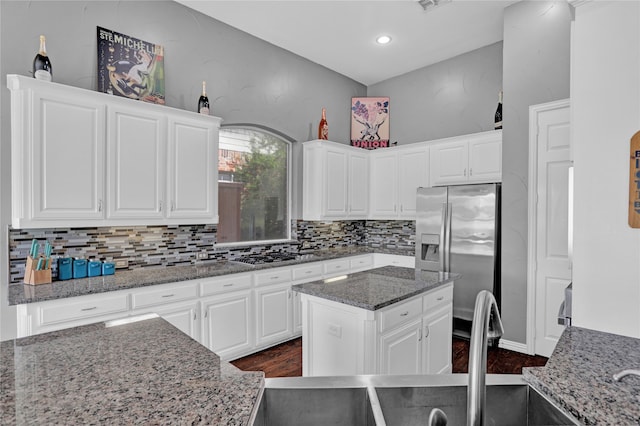 kitchen featuring white cabinets, a kitchen island, stone counters, appliances with stainless steel finishes, and dark hardwood / wood-style floors