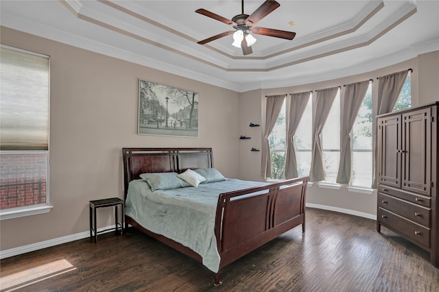 bedroom with crown molding, dark hardwood / wood-style floors, ceiling fan, and a raised ceiling