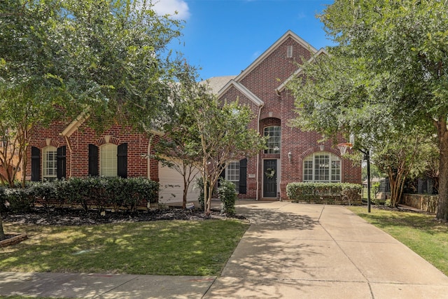 view of property featuring a garage and a front yard