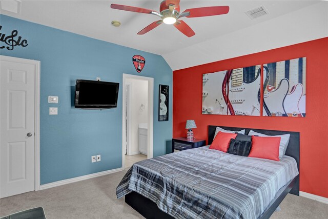 carpeted bedroom with connected bathroom, vaulted ceiling, and ceiling fan