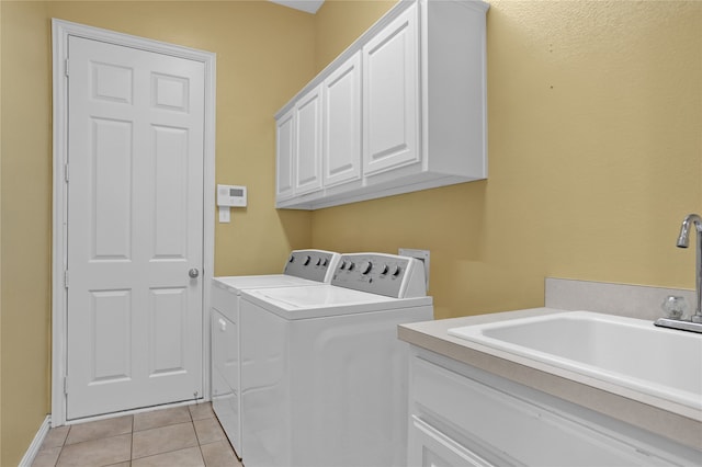 clothes washing area featuring separate washer and dryer, light tile patterned flooring, sink, and cabinets