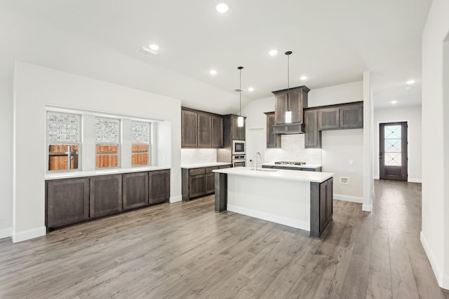 kitchen featuring hanging light fixtures, plenty of natural light, light wood-type flooring, and appliances with stainless steel finishes