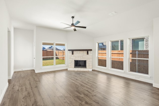 unfurnished living room with ceiling fan, dark hardwood / wood-style flooring, lofted ceiling, and a fireplace