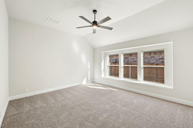 carpeted spare room with ceiling fan and vaulted ceiling