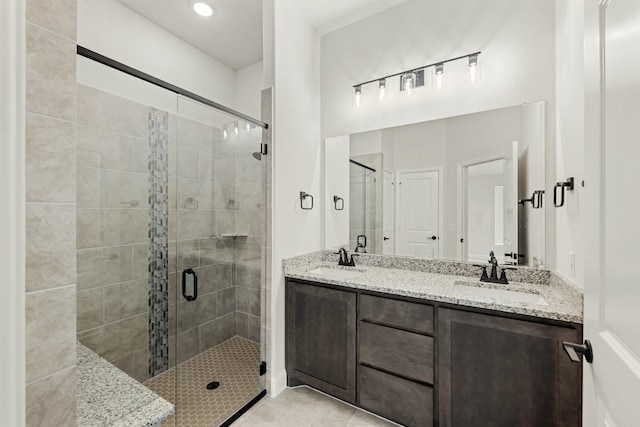 bathroom with tile patterned flooring, vanity, and a shower with shower door