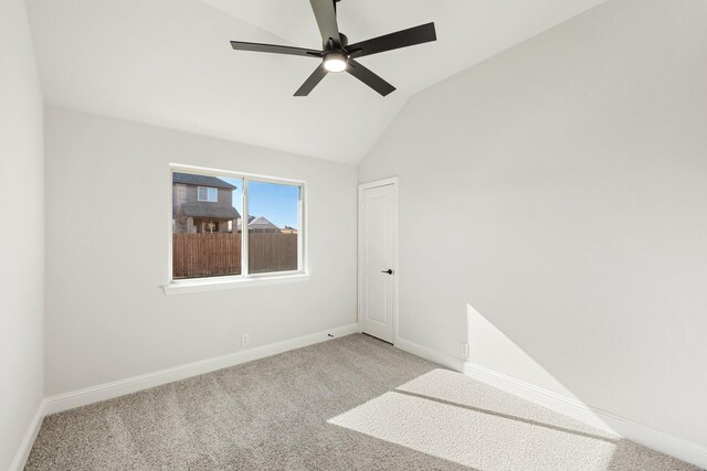 carpeted empty room featuring vaulted ceiling and ceiling fan