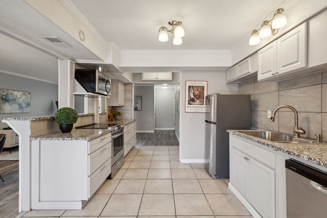 kitchen with stainless steel appliances, sink, white cabinetry, ornamental molding, and kitchen peninsula