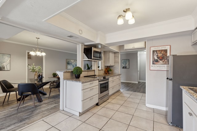 kitchen featuring a chandelier, appliances with stainless steel finishes, ornamental molding, white cabinets, and light tile patterned flooring