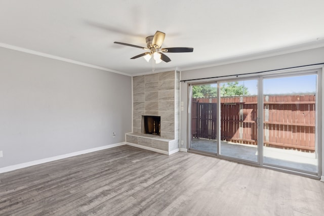 unfurnished living room with a tiled fireplace, ceiling fan, ornamental molding, and hardwood / wood-style floors