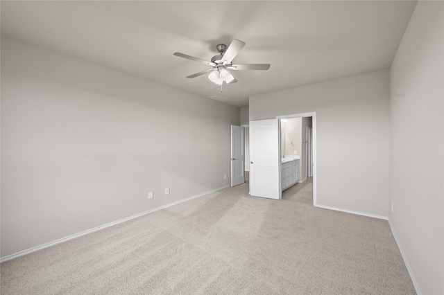 unfurnished bedroom with ceiling fan, light carpet, and ensuite bath