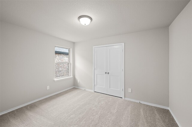 empty room with carpet and a textured ceiling