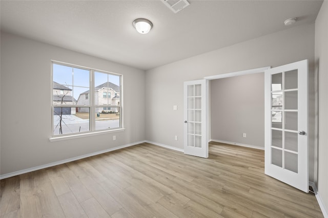 spare room featuring light wood-type flooring and french doors