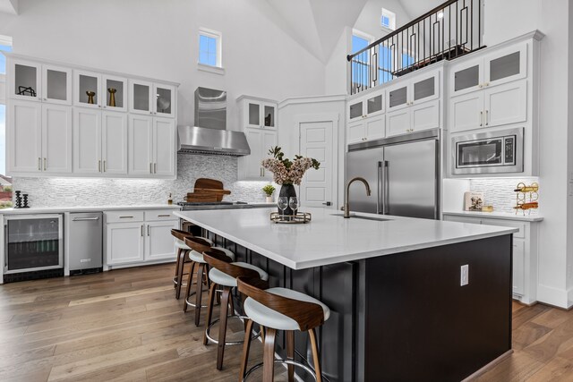 living room featuring ceiling fan, light hardwood / wood-style floors, a fireplace, and high vaulted ceiling