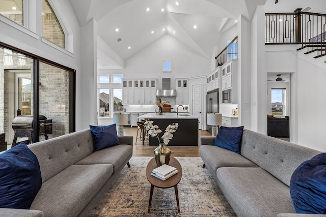 living room featuring sink, hardwood / wood-style floors, and a towering ceiling