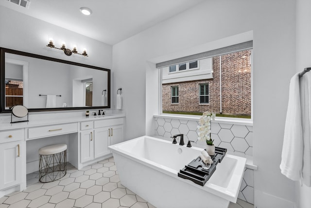 bathroom with vanity, backsplash, and a bathtub