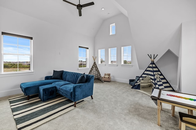 carpeted living room featuring ceiling fan and high vaulted ceiling