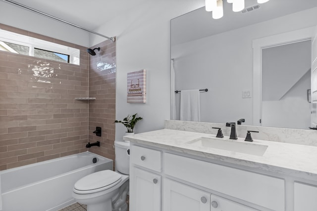 full bathroom featuring tiled shower / bath, vanity, and toilet