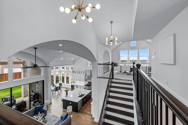 interior space featuring light hardwood / wood-style floors, high vaulted ceiling, and a notable chandelier