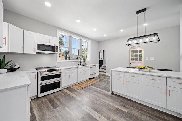 kitchen with sink, white cabinetry, decorative light fixtures, dark hardwood / wood-style floors, and white appliances