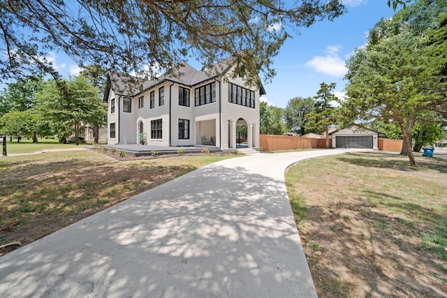 view of front of house featuring an outbuilding, a garage, and a front lawn