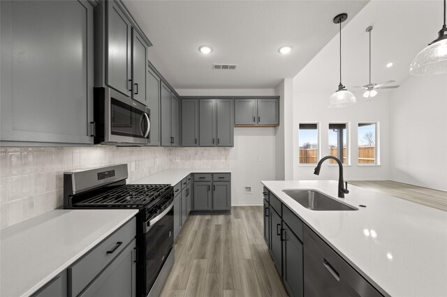 kitchen featuring stainless steel appliances, white cabinets, and light hardwood / wood-style floors