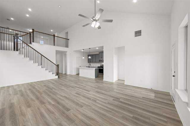 living room with lofted ceiling, ceiling fan, and light colored carpet