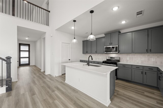 kitchen featuring decorative backsplash, stainless steel appliances, white cabinets, and light hardwood / wood-style floors