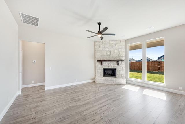 unfurnished living room with a fireplace, light wood-type flooring, and ceiling fan