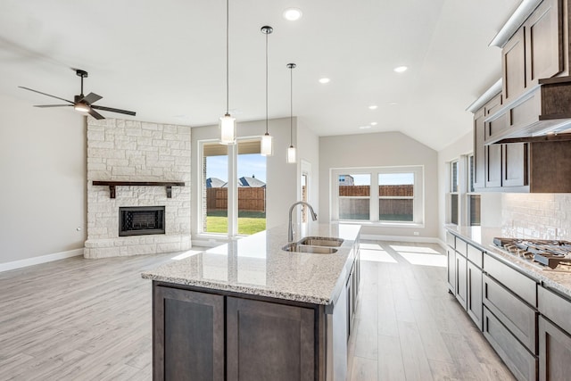 kitchen featuring hanging light fixtures, stainless steel gas stovetop, a healthy amount of sunlight, and sink