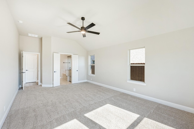 unfurnished bedroom with ceiling fan, lofted ceiling, light carpet, and connected bathroom